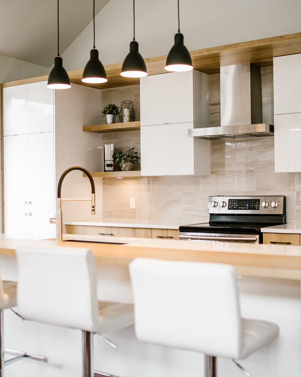 Cuisine créative : portes blanches lustrées et laminé chêne, tablettes ouvertes, suspensions noires, tabourets blancs