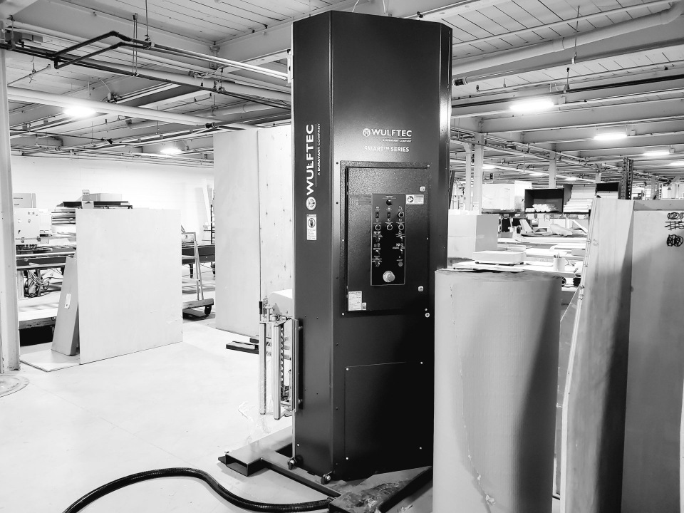Emballeuse automatique Wulftec noire dans l’usine, photo en noir et blanc.